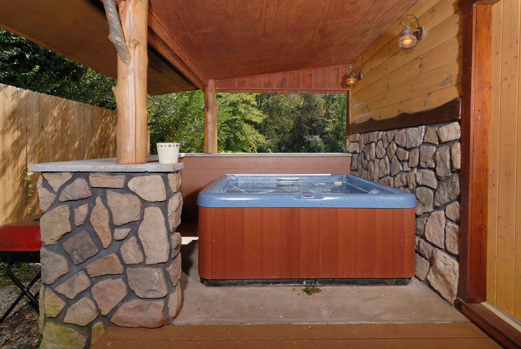 Pigeon Forge Private Cabin that has a private hot tub area underneath a covered porch